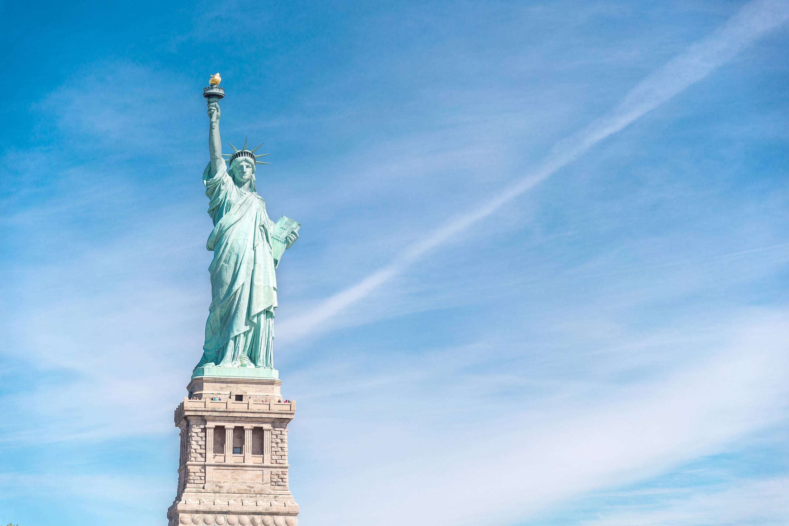 View of the United States flag and the Statue of Liberty on Liberty Island on October 10, 2019 in New York